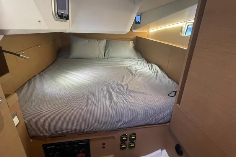 Atticus Yacht Photos Pics Port aft cozy cabin interior of 2022 Jeanneau Sun Odyssey 490 sailboat with comfortable bedding.