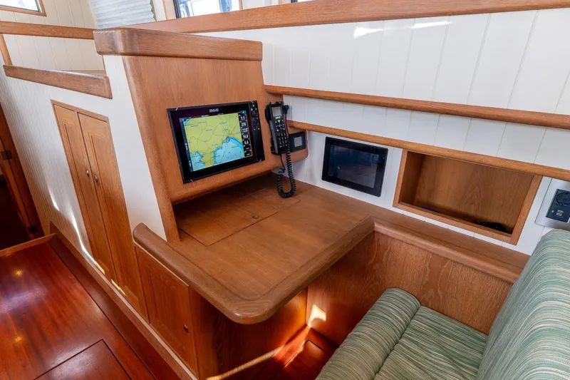 Jaleo Yacht Photos Pics Cozy wooden boat interior with navigation equipment, featuring a Puffin 50 model from 2019.