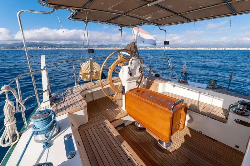 Jaleo Yacht Photos Pics Cockpit of 2019 Puffin 50 sailboat with wooden deck and steering wheel, ocean view.