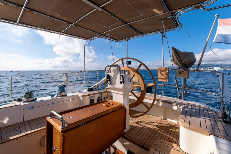 Jaleo Yacht Photos Pics Sailing yacht Puffin 50, 2019 model, with wooden deck and steering wheel, on open sea.