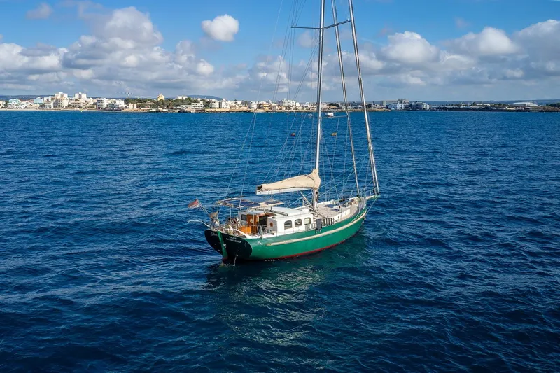 Jaleo Yacht Photos Pics Sailboat Puffin 50, 2019 model, anchored in clear blue ocean near coastal city.