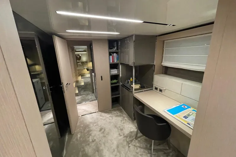  Yacht Photos Pics Luxurious interior of 2024 Cranchi 67 Sessantasette Fly yacht with modern desk and shelving.