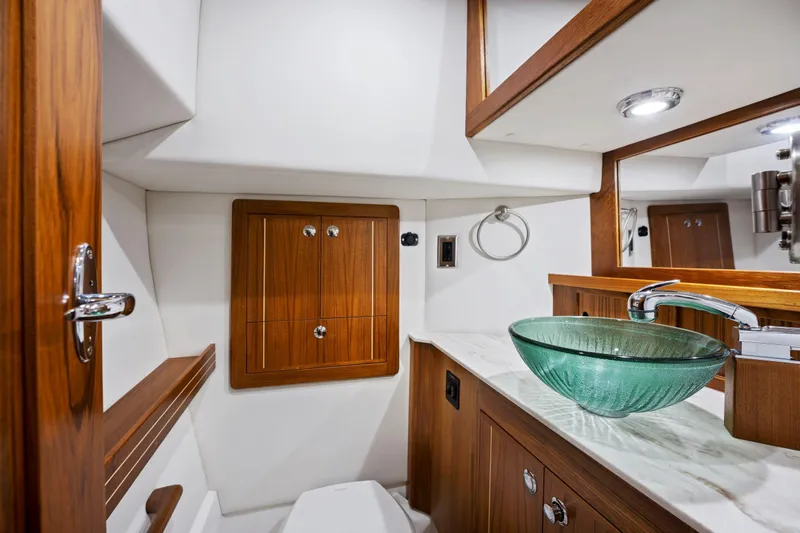  Yacht Photos Pics Luxurious Aspen C107 2026 yacht bathroom with glass sink and wooden cabinetry.