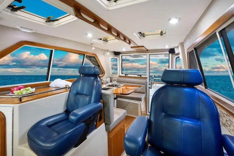  Yacht Photos Pics Luxurious interior of 2026 Aspen C107 boat with blue leather seats and ocean view.