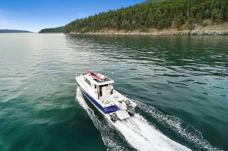  Yacht Photos Pics Aspen C107 boat cruising on a serene lake with forested shoreline, 2026 model.