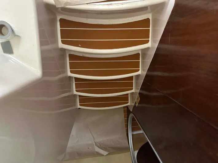 Felice Yacht Photos Pics Interior view of a 1998 Fountaine Pajot Athena 38 catamaran, featuring wooden steps and white trim.