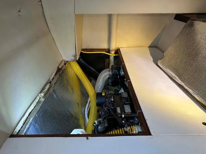 Felice Yacht Photos Pics Engine compartment of a 1998 Fountaine Pajot Athena 38 catamaran, featuring yellow hoses.