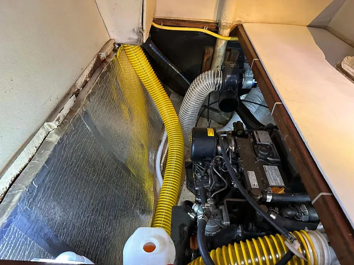 Felice Yacht Photos Pics Engine compartment of a 1998 Fountaine Pajot Athena 38 catamaran with visible hoses and insulation.