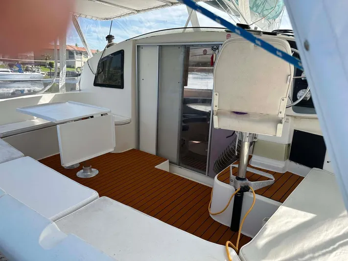 Felice Yacht Photos Pics 1998 Fountaine Pajot Athena 38 catamaran cockpit with seating, table, and helm station.