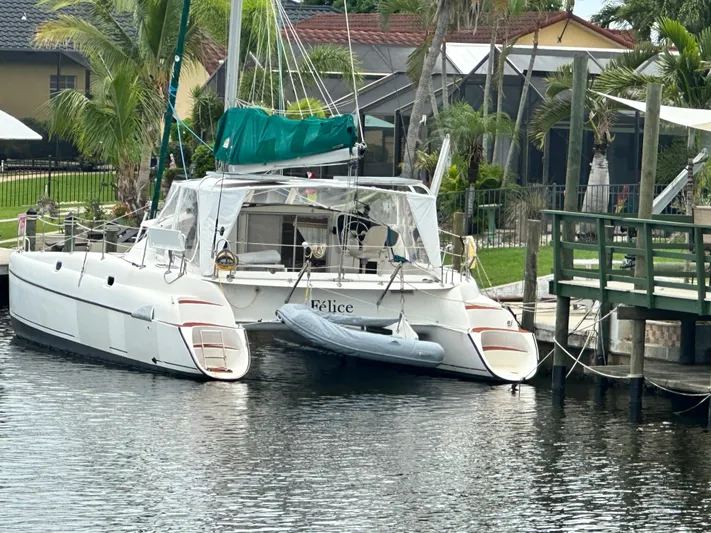 Felice Yacht Photos Pics 1998 Fountaine Pajot Athena 38 catamaran docked by a lush waterfront.