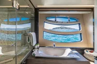 Luxurious bathroom on 2016 Pershing 82 yacht with ocean view through unique windows.