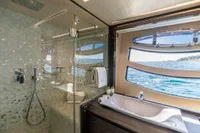 Luxurious bathroom on 2016 Pershing 82 yacht with ocean view through large window.