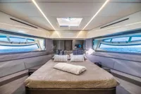 Luxurious interior of 2016 Pershing 82 yacht with panoramic windows and elegant bedding.