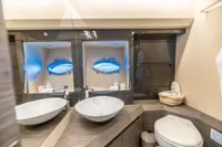 Luxurious bathroom on 2016 Pershing 82 yacht with modern fixtures and porthole window.