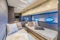 Luxurious 2016 Pershing 82 yacht cabin with modern decor and ocean-view portholes.
