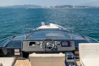 Cockpit view of 2016 Pershing 82 yacht navigating open sea with distant coastline.