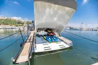 2016 Pershing 82 yacht with open garage, docked in a scenic marina.