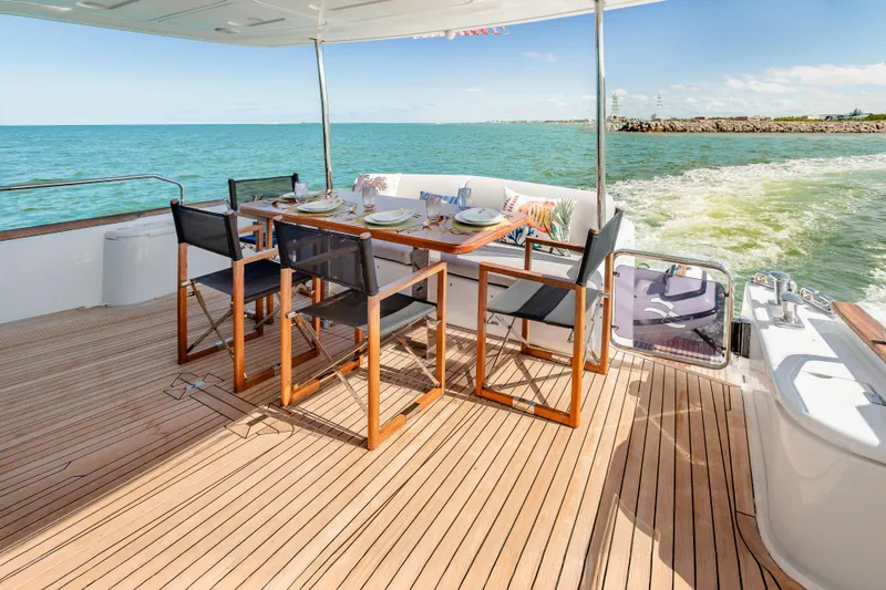 Viakarey Yacht Photos Pics Luxury dining area on 2023 Sirena 58 yacht, overlooking serene ocean waters.
