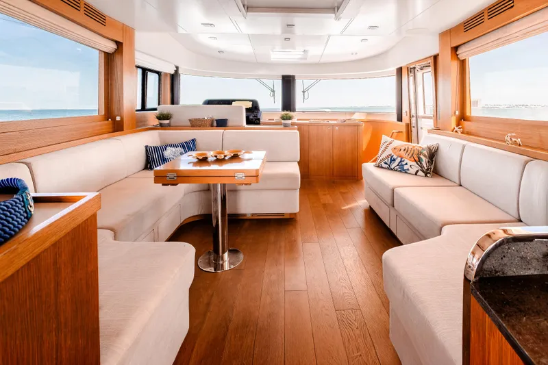Viakarey Yacht Photos Pics Luxurious interior of 2023 Sirena 58 yacht with elegant wood finishes and plush seating.