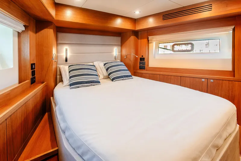 Viakarey Yacht Photos Pics Luxurious cabin interior of 2023 Sirena 58 yacht with cozy bed and wooden accents.