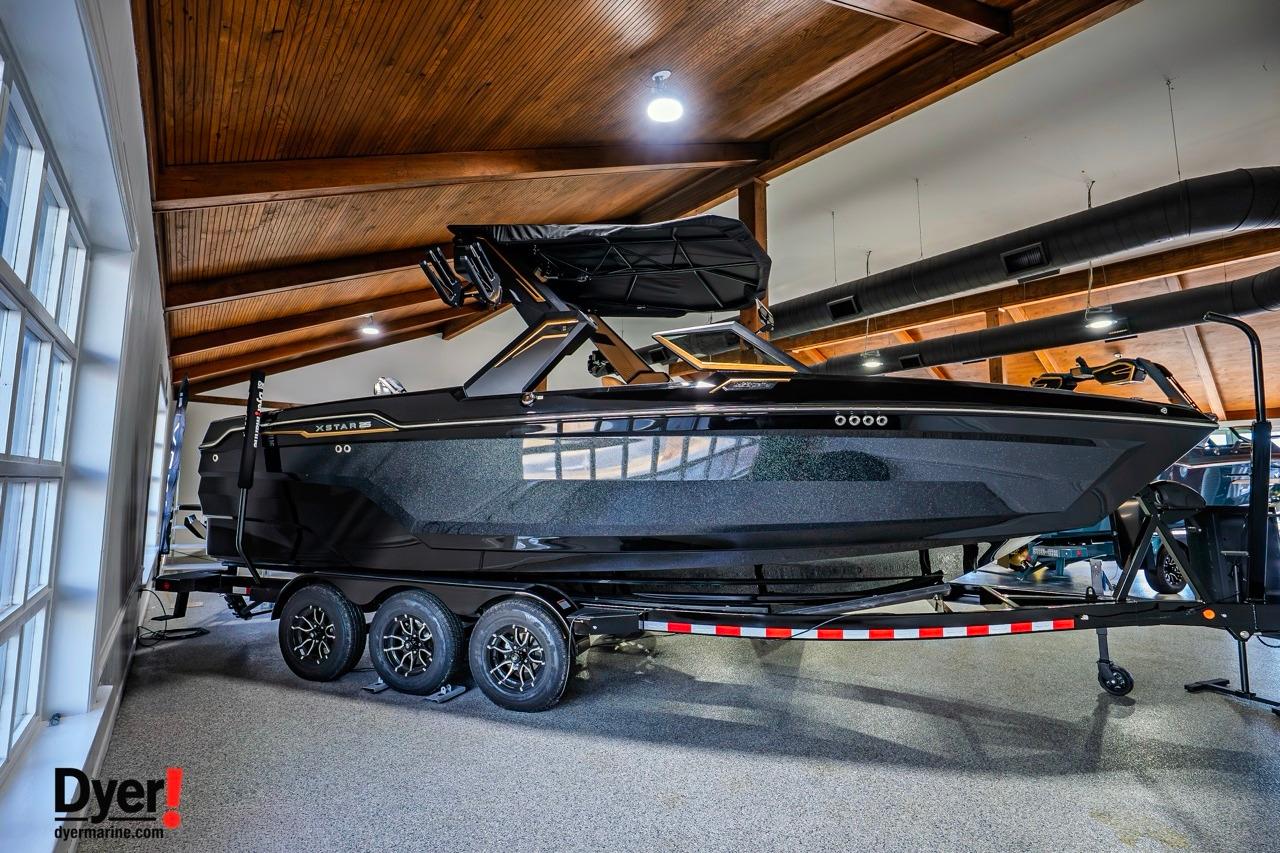 2026 MasterCraft XStar 25 boat in showroom, sleek black design on trailer.