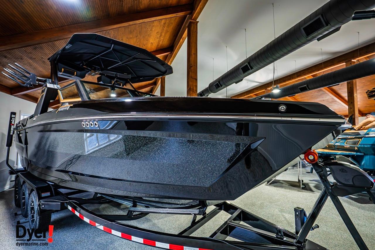 2026 MasterCraft XStar 25 boat in showroom, sleek black design, on trailer.