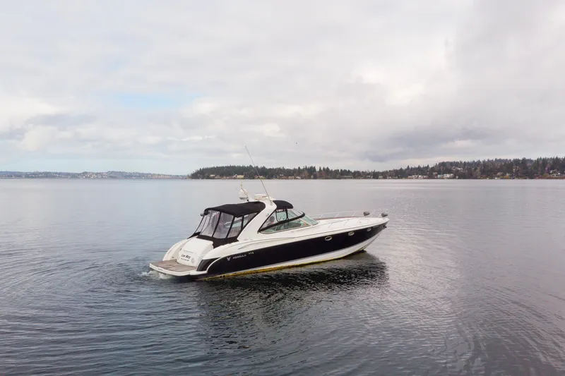  Yacht Photos Pics 2005 Formula 400 Super Sport boat cruising on a calm lake under cloudy skies.