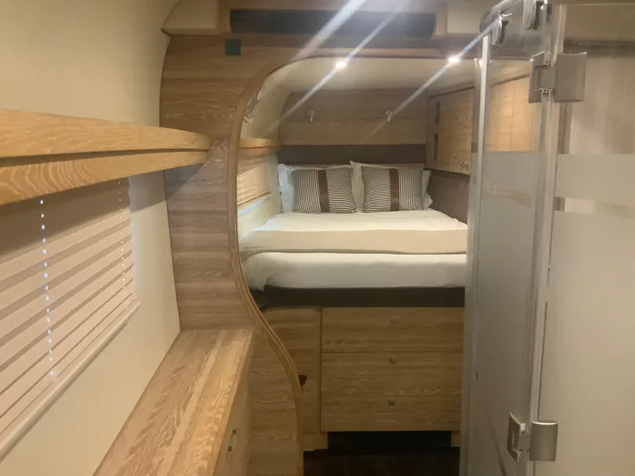 Vanquish Yacht Photos Pics Luxurious 2018 Xquisite Yachts X5 interior cabin with modern wood finish and cozy bedding.