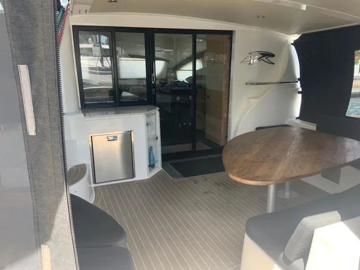 Vanquish Yacht Photos Pics 2018 Xquisite Yachts X5 interior with wooden table, seating, and kitchenette.