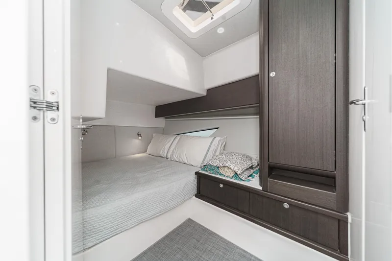 R&r 5 Yacht Photos Pics 2022 Intrepid 477 Evolution cabin interior with bed, pillows, and storage.