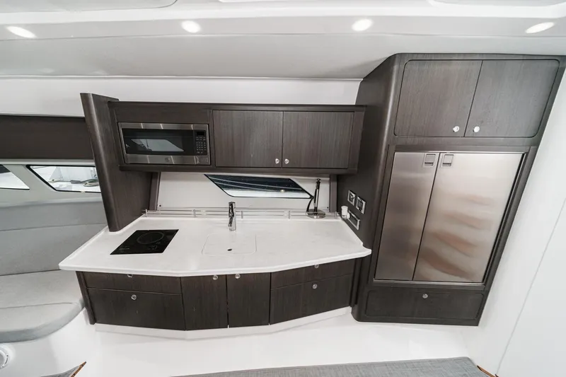 R&r 5 Yacht Photos Pics Modern kitchen interior of 2022 Intrepid 477 Evolution yacht with sleek cabinetry and appliances.