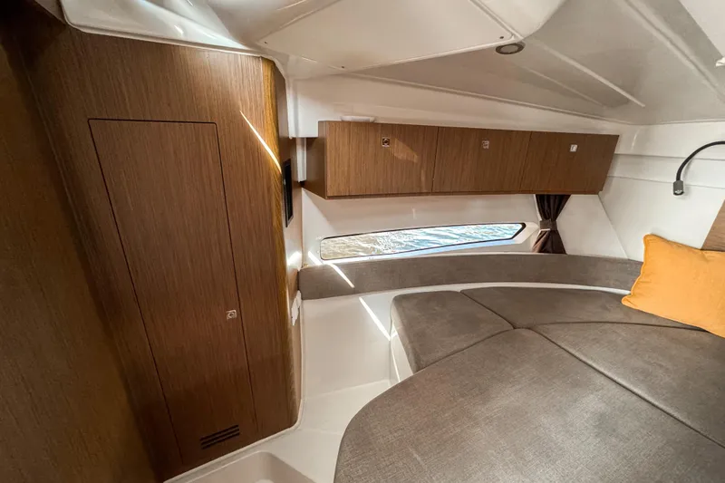  Yacht Photos Pics 2025 Beneteau Antares 9 cabin interior with wood finish and cozy seating area.