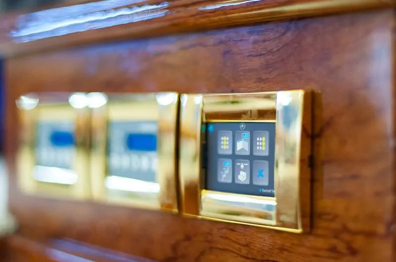 Houbara Yacht Photos Pics Control panel on 2012 Sunreef 82 DD yacht with gold accents and wood finish.