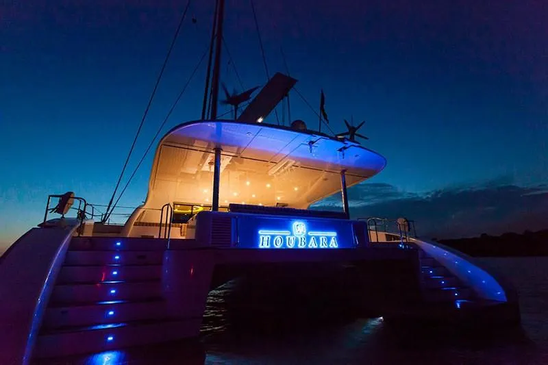 Houbara Yacht Photos Pics Luxurious Sunreef 82 DD yacht illuminated at night, showcasing elegant design and ambient lighting.