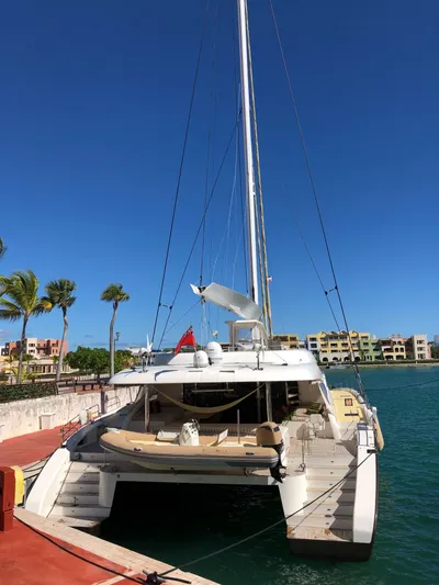 Houbara Yacht Photos Pics Luxury Sunreef 82 DD catamaran docked, 2012 model, clear blue sky, waterfront view.