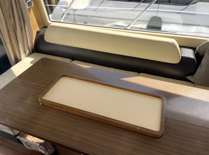 Concepcion 1641 Yacht Photos Pics Interior of 2013 Azimut 55S yacht with wooden table and cushioned seating.