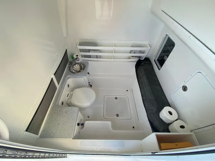  Yacht Photos Pics 2022 Invincible 42 Open Fisherman boat interior with toilet, sink, and storage shelves.