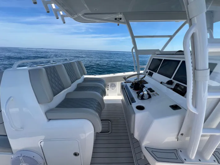  Yacht Photos Pics 2022 Invincible 42 Open Fisherman boat interior with helm and seating, on open water.