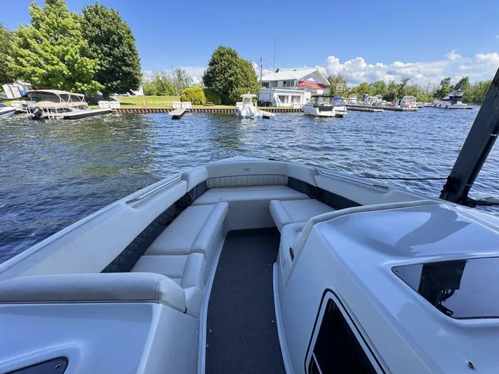  Yacht Photos Pics 2017 Cobalt R35 boat on a scenic lake with docked boats and lush greenery.