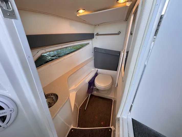  Yacht Photos Pics Interior of a 2017 Cobalt R35 boat bathroom with modern fixtures and window view.