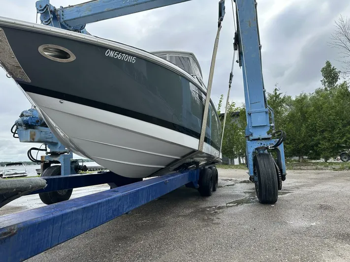  Yacht Photos Pics 2017 Cobalt R35 boat on a blue lift, overcast sky, trees in background.