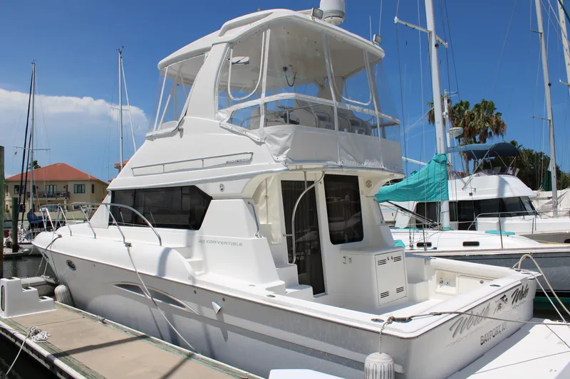 Worth The Wake Yacht Photos Pics 2006 Silverton 42 Convertible yacht docked at a marina under clear blue skies.