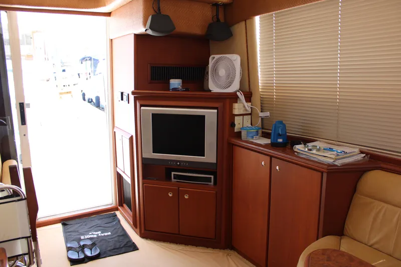 Worth The Wake Yacht Photos Pics Interior of 2006 Silverton 42 Convertible yacht with TV and wooden cabinetry.
