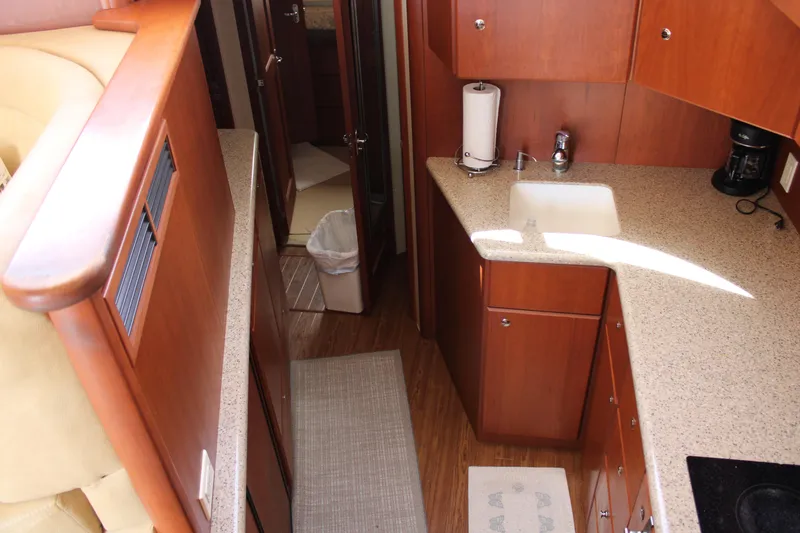 Worth The Wake Yacht Photos Pics Interior of 2006 Silverton 42 Convertible yacht with modern kitchen and wood cabinetry.
