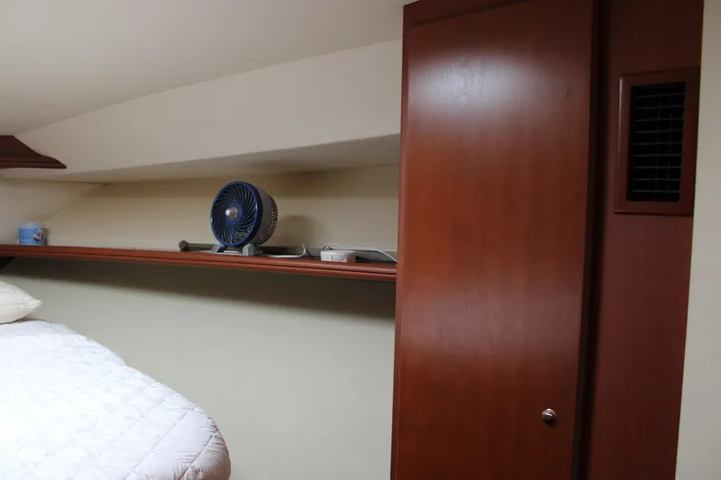 Worth The Wake Yacht Photos Pics 2006 Silverton 42 Convertible cabin interior with wooden cabinetry and shelf fan.