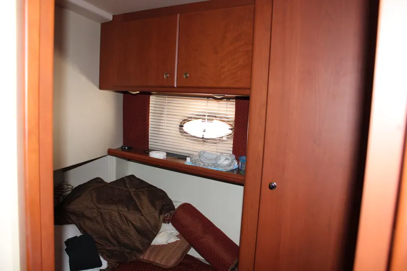 Worth The Wake Yacht Photos Pics 2006 Silverton 42 Convertible cabin interior with wooden cabinets and porthole window.