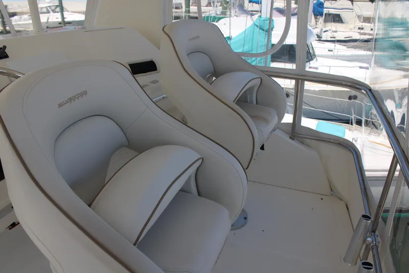 Worth The Wake Yacht Photos Pics 2006 Silverton 42 Convertible boat interior with two white captain's chairs.