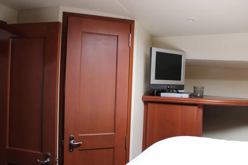 Worth The Wake Yacht Photos Pics Interior of 2006 Silverton 42 Convertible yacht with wooden door and TV.