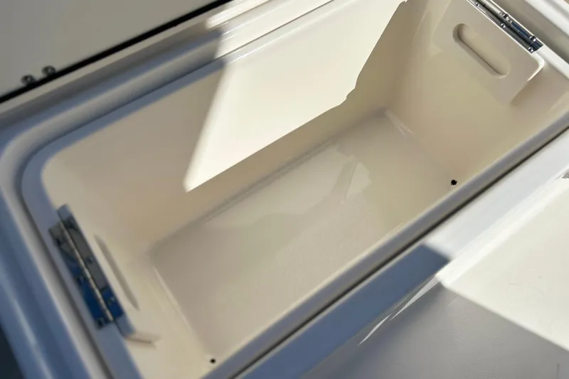  Yacht Photos Pics 2023 Key West 263 FS boat storage compartment, open and empty, with sunlight casting shadows.