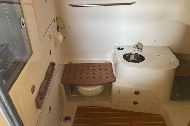  Yacht Photos Pics 2026 Grady-White Canyon 336 boat interior with compact bathroom and wooden accents.